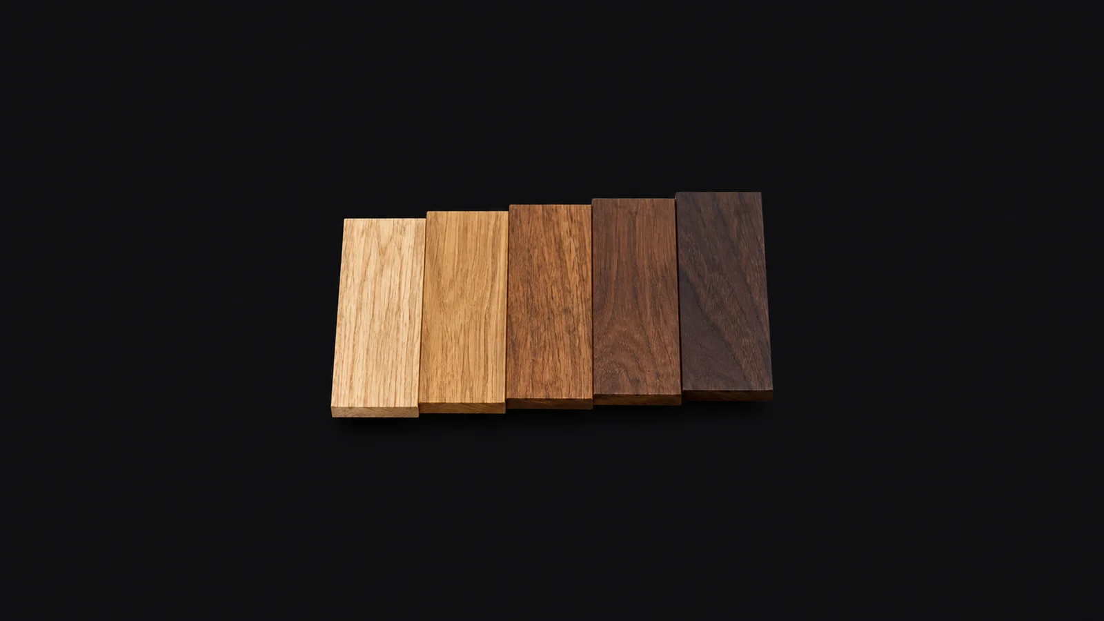 Abstract a gradient of wood-stain tones stepping from pale oak to dark walnut motif centred on a seamless deep charcoal near-black studio background, generous empty margin for overlaid branding