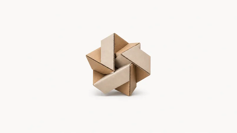 Abstract a tessellation of folded corrugated-card facets motif centred on a seamless pale off-white studio background, generous empty margin for overlaid branding