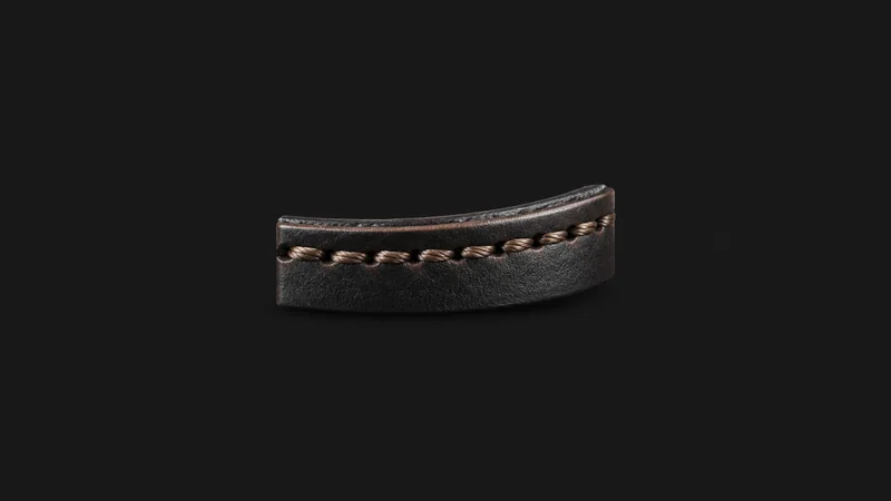 Abstract a row of saddle stitches running along a leather edge motif centred on a seamless deep charcoal near-black studio background, generous empty margin for overlaid branding