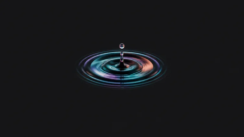 Abstract concentric ripples of coloured ink spreading from a central drop motif centred on a seamless deep charcoal near-black studio background, generous empty margin for overlaid branding