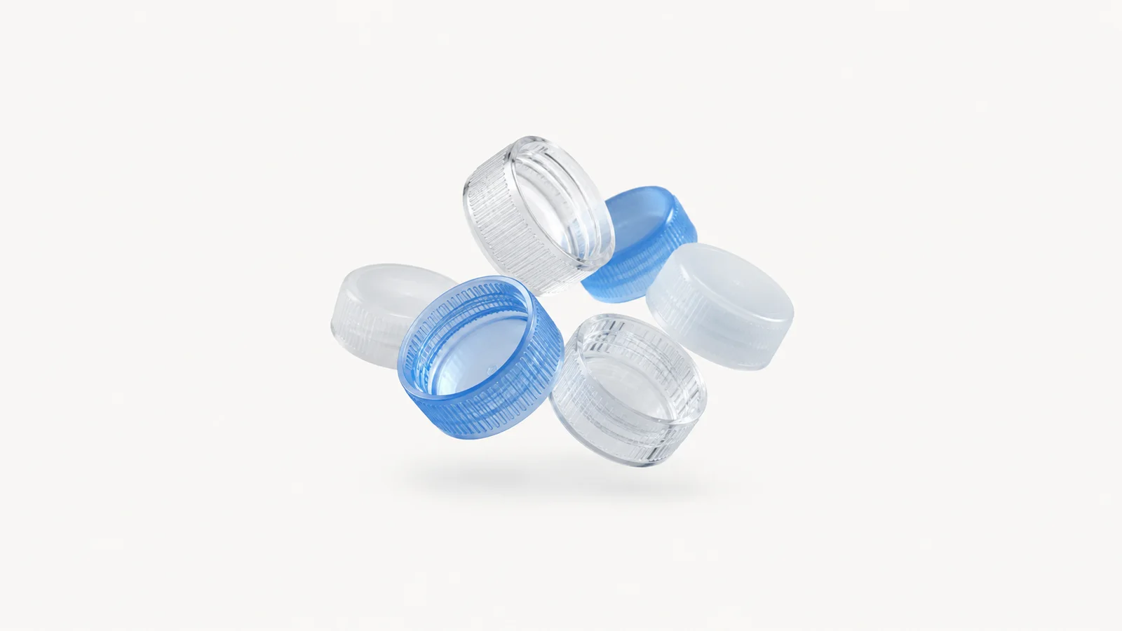 Abstract a cascade of translucent bottle caps tumbling in cool light motif centred on a seamless pale off-white studio background, generous empty margin for overlaid branding