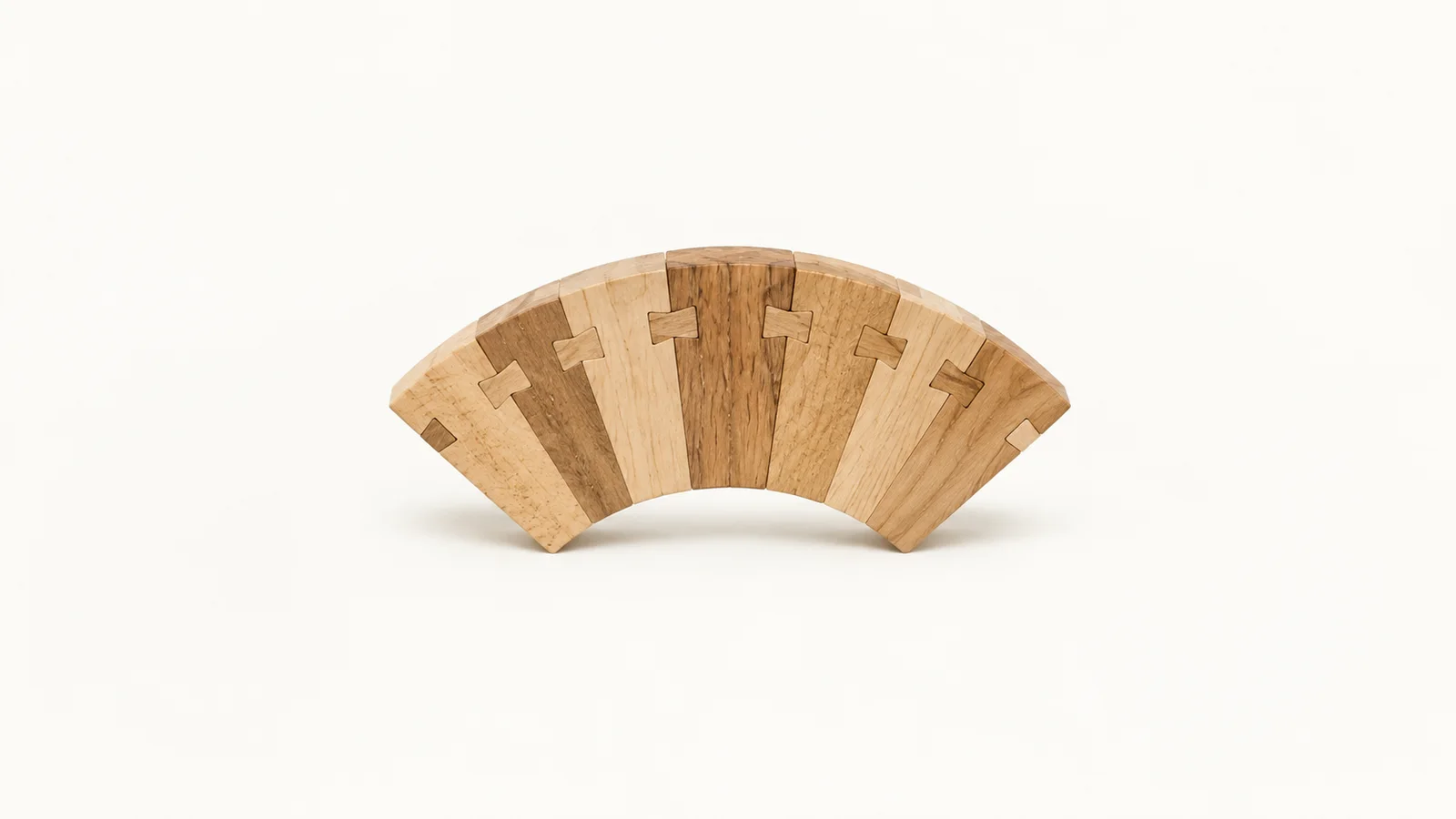 Abstract a fan of dovetail-joint silhouettes interlocking in a curve motif centred on a seamless pale off-white studio background, generous empty margin for overlaid branding