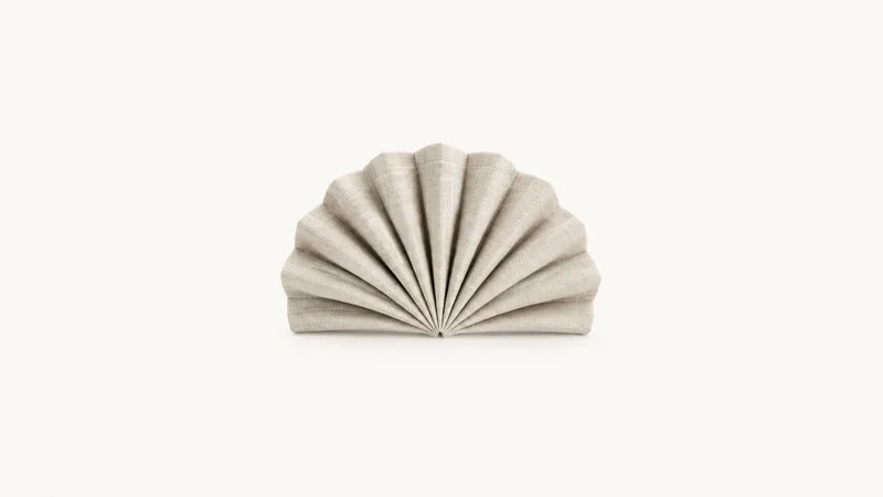 Abstract a pleated fan of upholstery fabric gathering to a point motif centred on a seamless pale off-white studio background, generous empty margin for overlaid branding