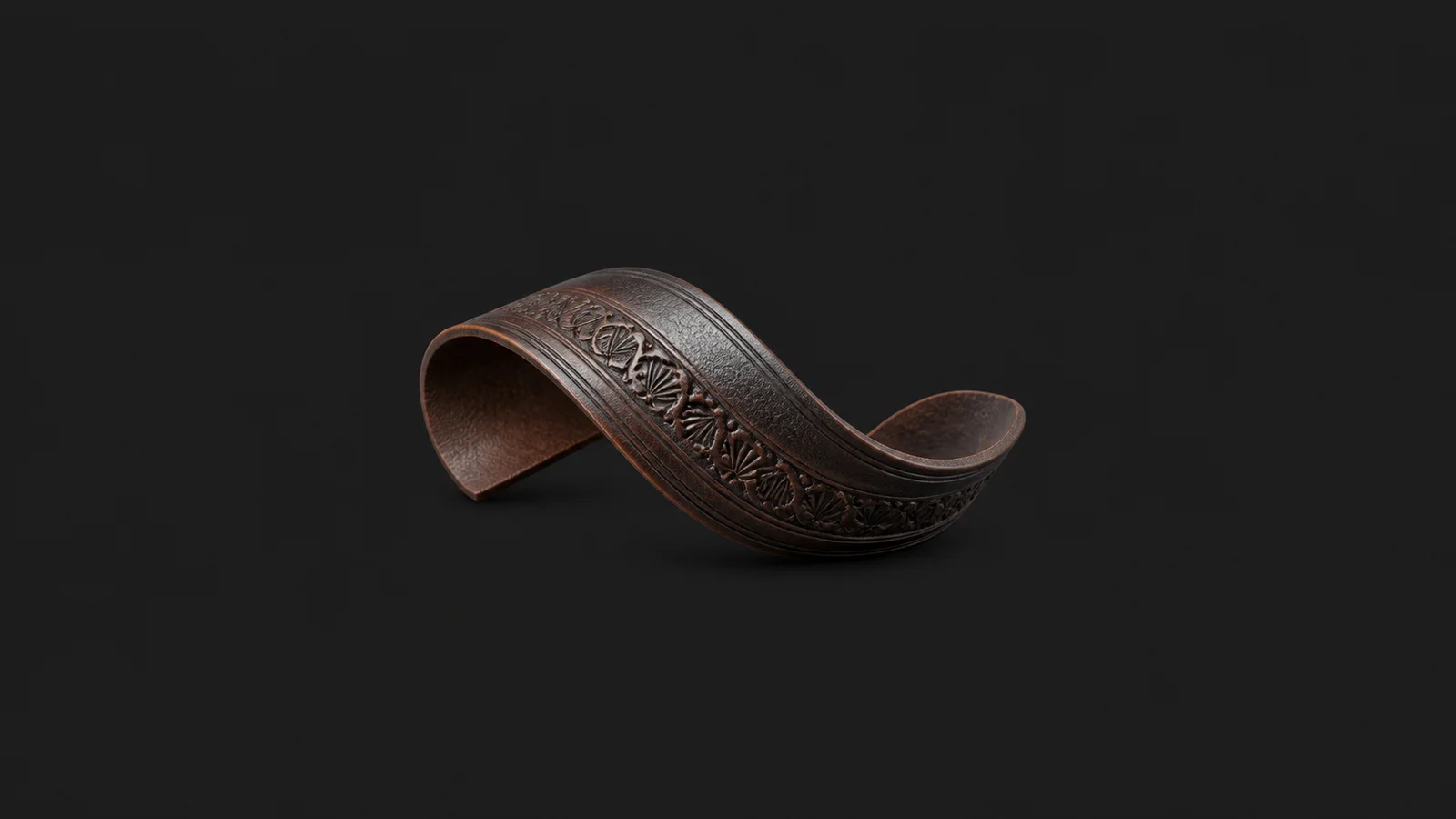 Abstract a curved sweep of tooled leather with a border stamp motif centred on a seamless deep charcoal near-black studio background, generous empty margin for overlaid branding
