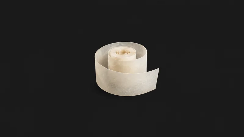 Abstract an unfurled ribbon of vellum spiralling into a tight bound scroll motif centred on a seamless deep charcoal near-black studio background, generous empty margin for overlaid branding