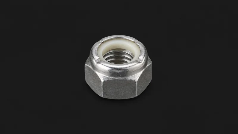 Isolated a self-locking nylon-insert nut centred on a seamless deep charcoal near-black studio background, generous empty margin on every side for overlaid branding
