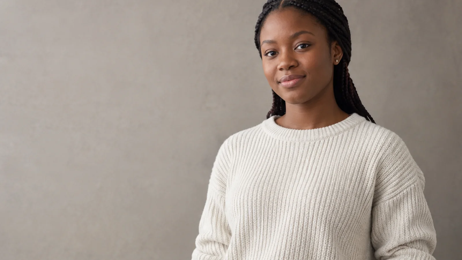 Mid-length portrait of a Black African teenager in casual everyday clothing, professional portraits, soft even indoor light, plain working backdrop with copy space
