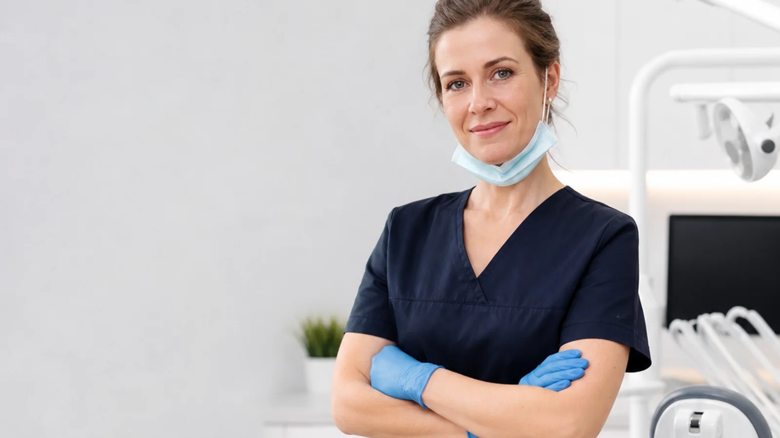 Mid-length portrait of a dentist, dental, soft even indoor light, plain working backdrop with copy space