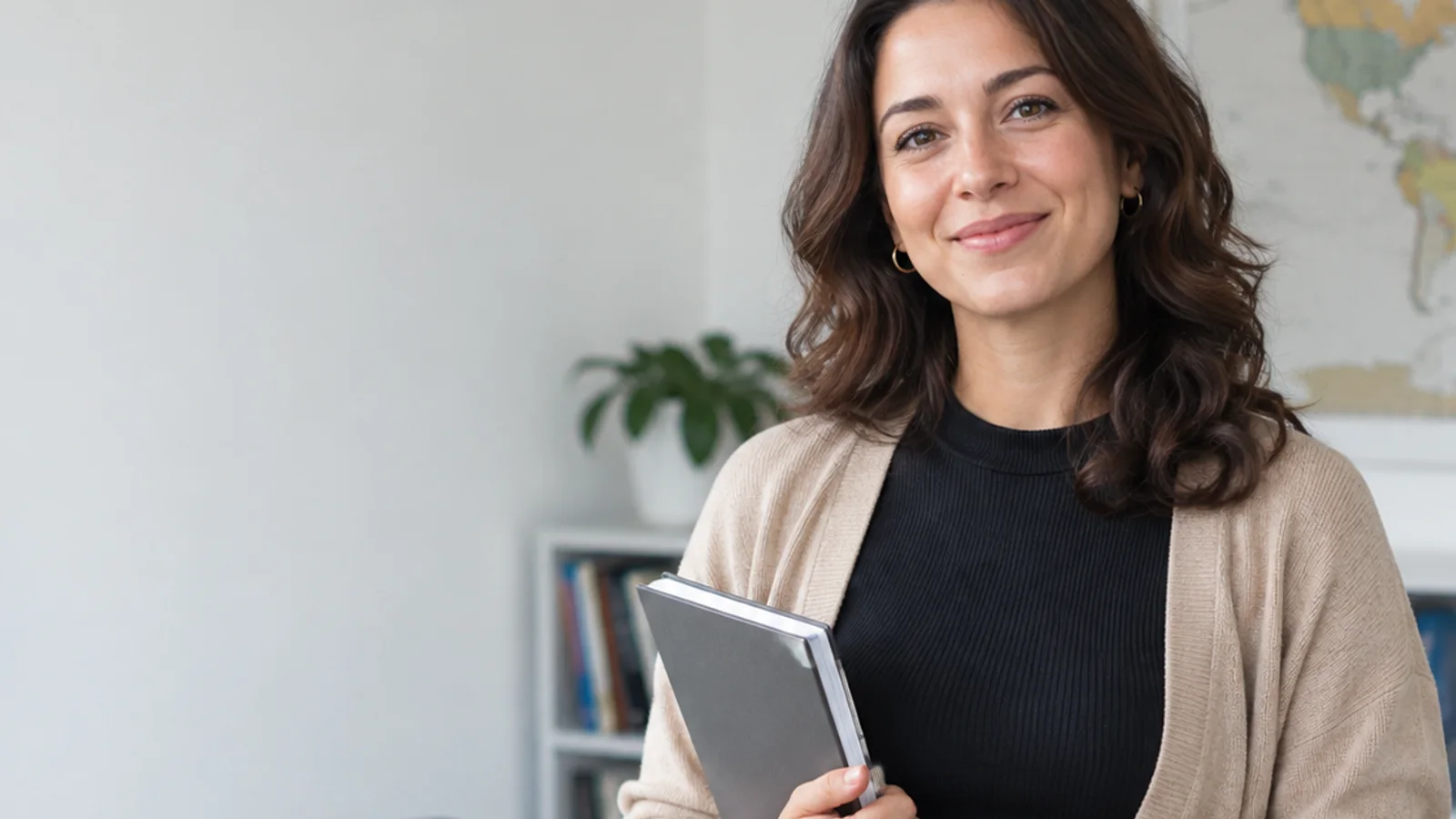 Mid-length portrait of a conversation tutor, language school, soft even indoor light, plain working backdrop with copy space